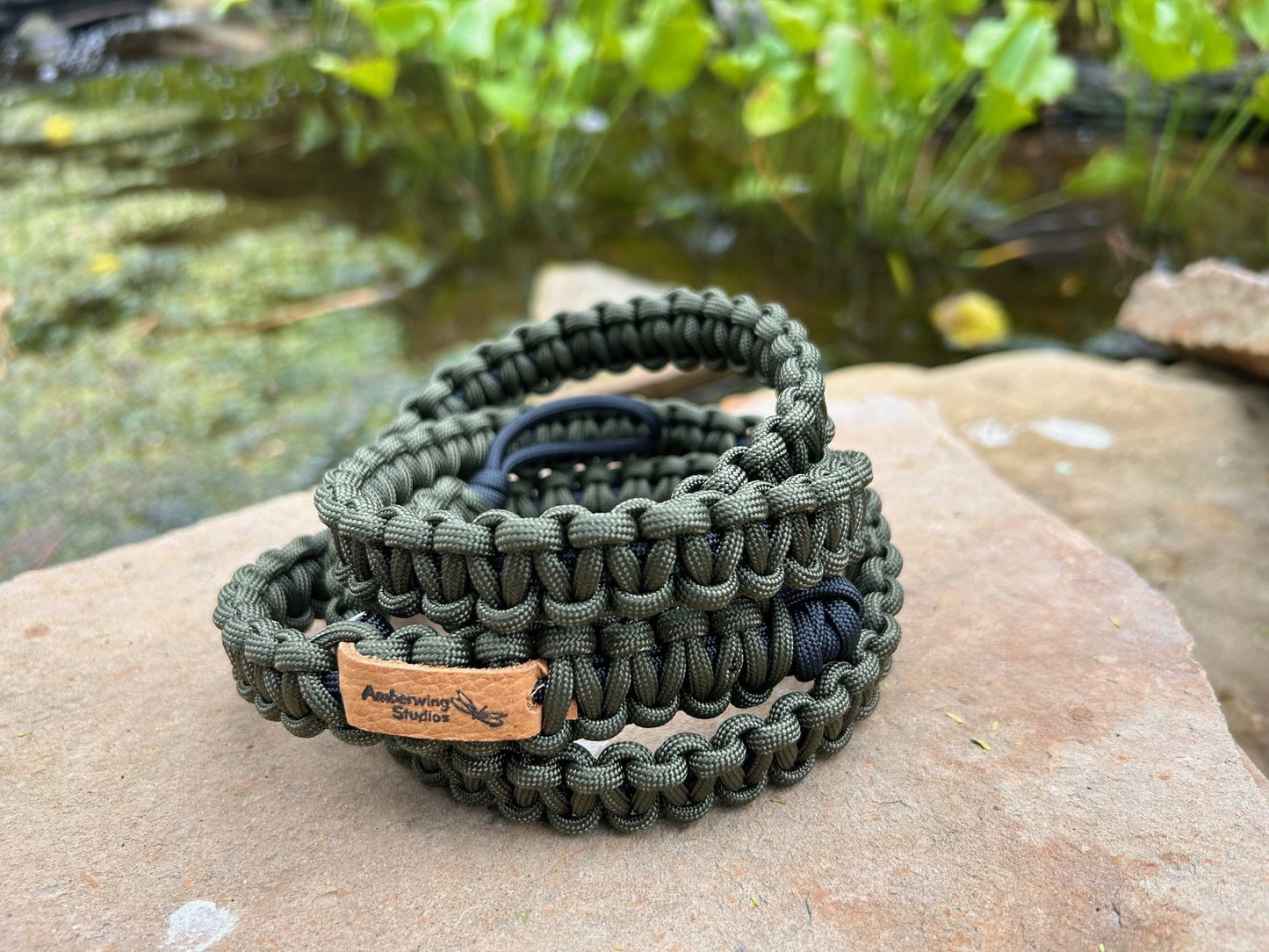 Photo of a Venture Strap that is set on top of a rock for a close-up view. The Venture Strap is a binocular or camera strap made of sturdy paracord. The strap is worn across the body and is more comfortable and durable that traditional binocular harnesses or camera straps.